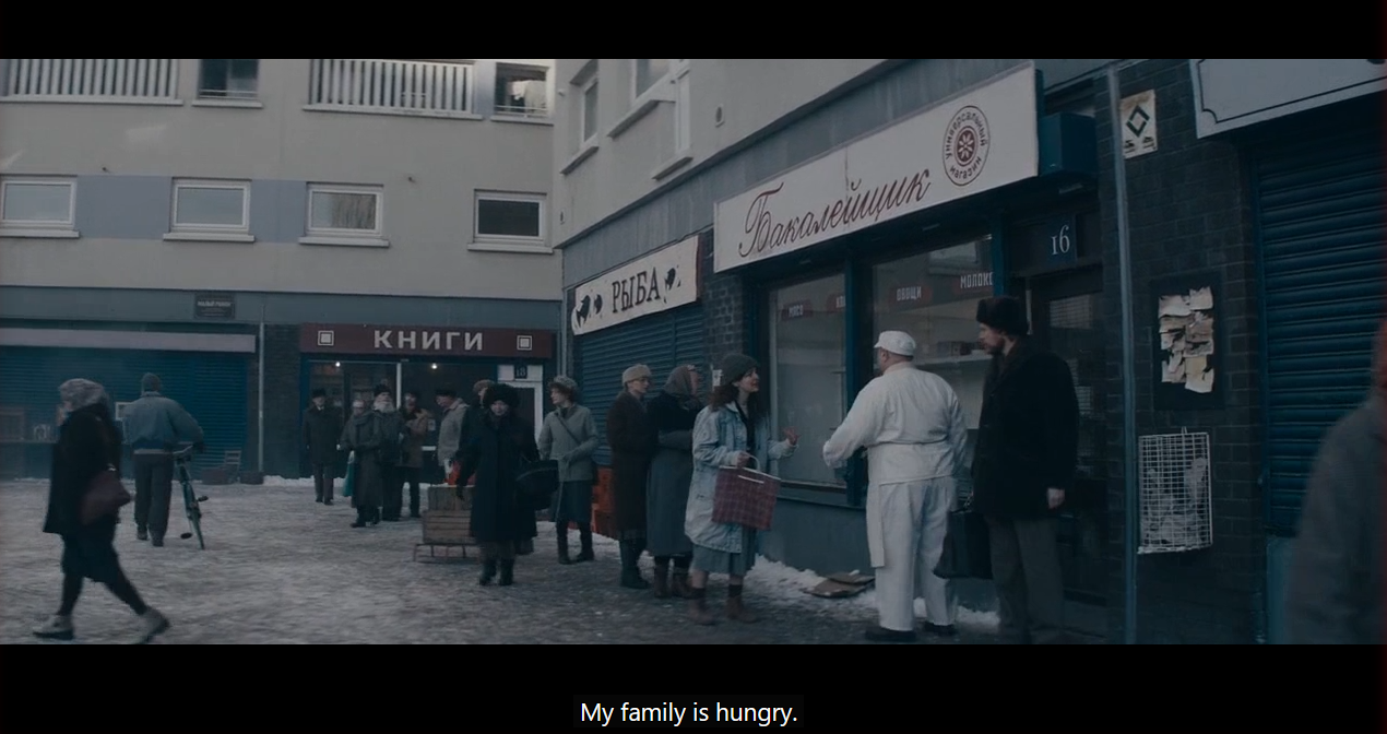 very grey russia scene of a food line. a woman is saying My family is hungry.