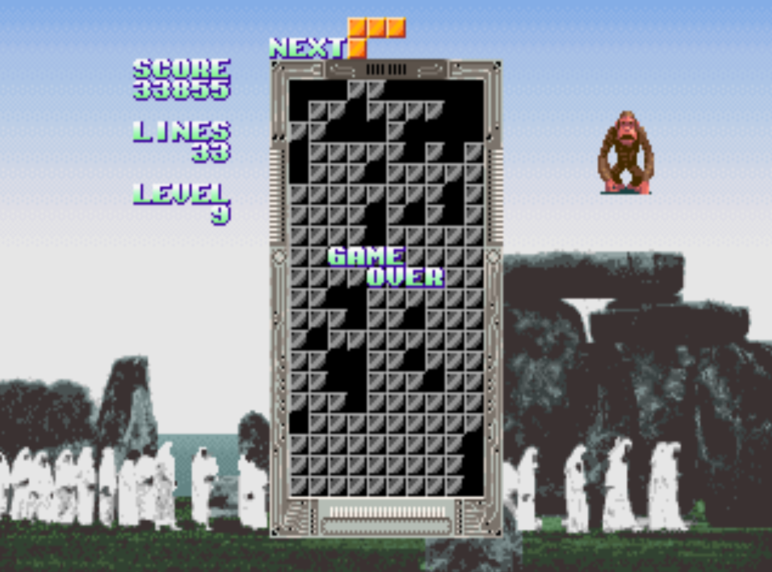 Game over on a background with white cloaked figures at Stonehenge. The monkey is there too and looks very vacant.